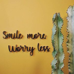 Medinis pakabinamas užrašas "Smile more worry less"